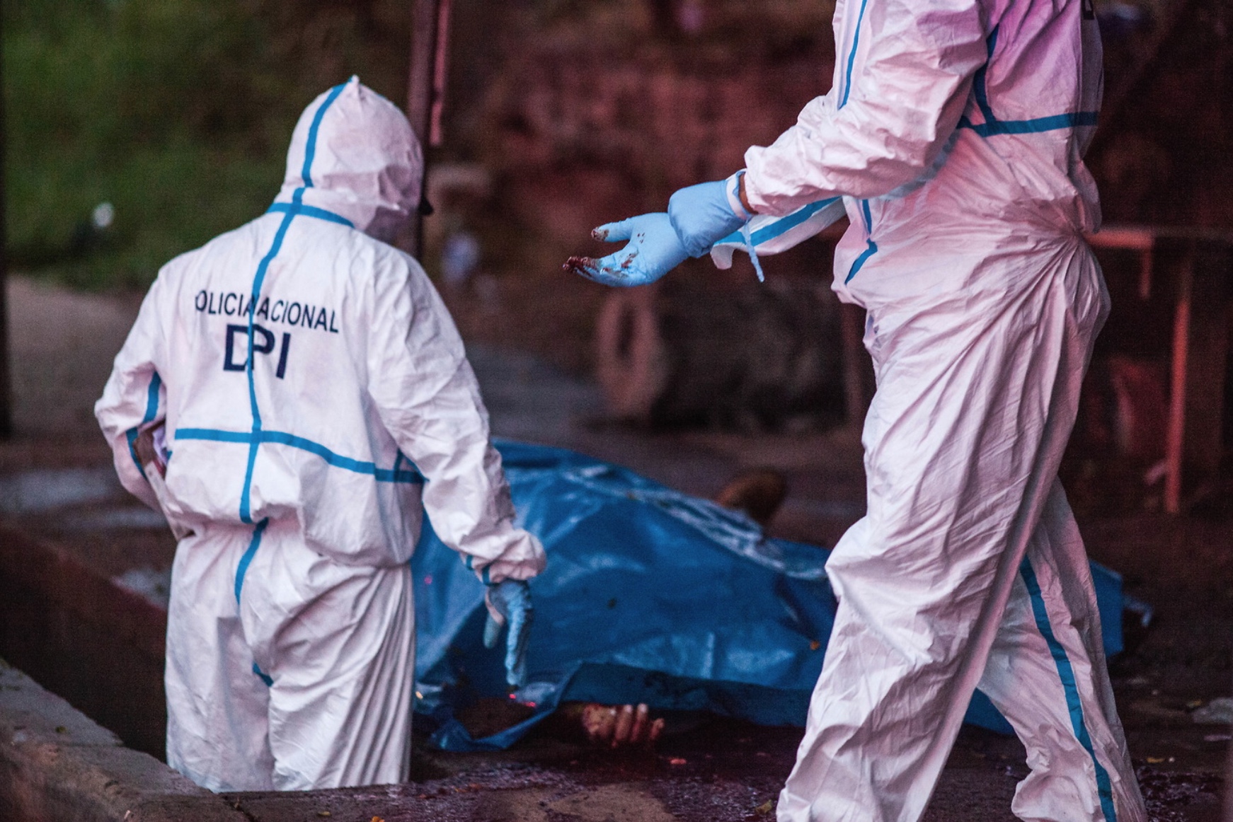 A forensics team working to document the death of taxi driver José Manuel Moradel, 45, murder in the street. 45 bullet shells were found at the scene. 8th August 2017.