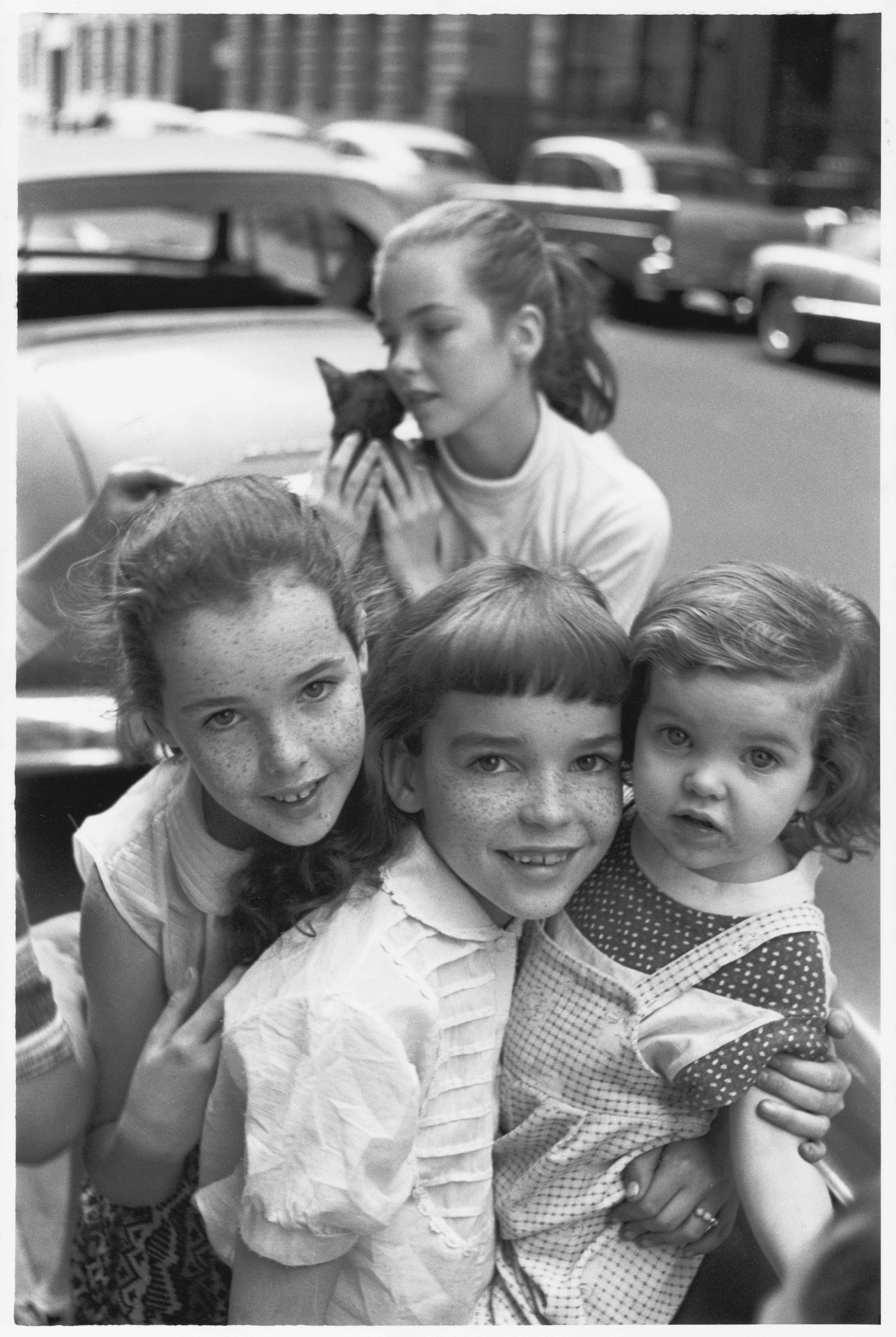Four related girls, one holding a cat, 1957