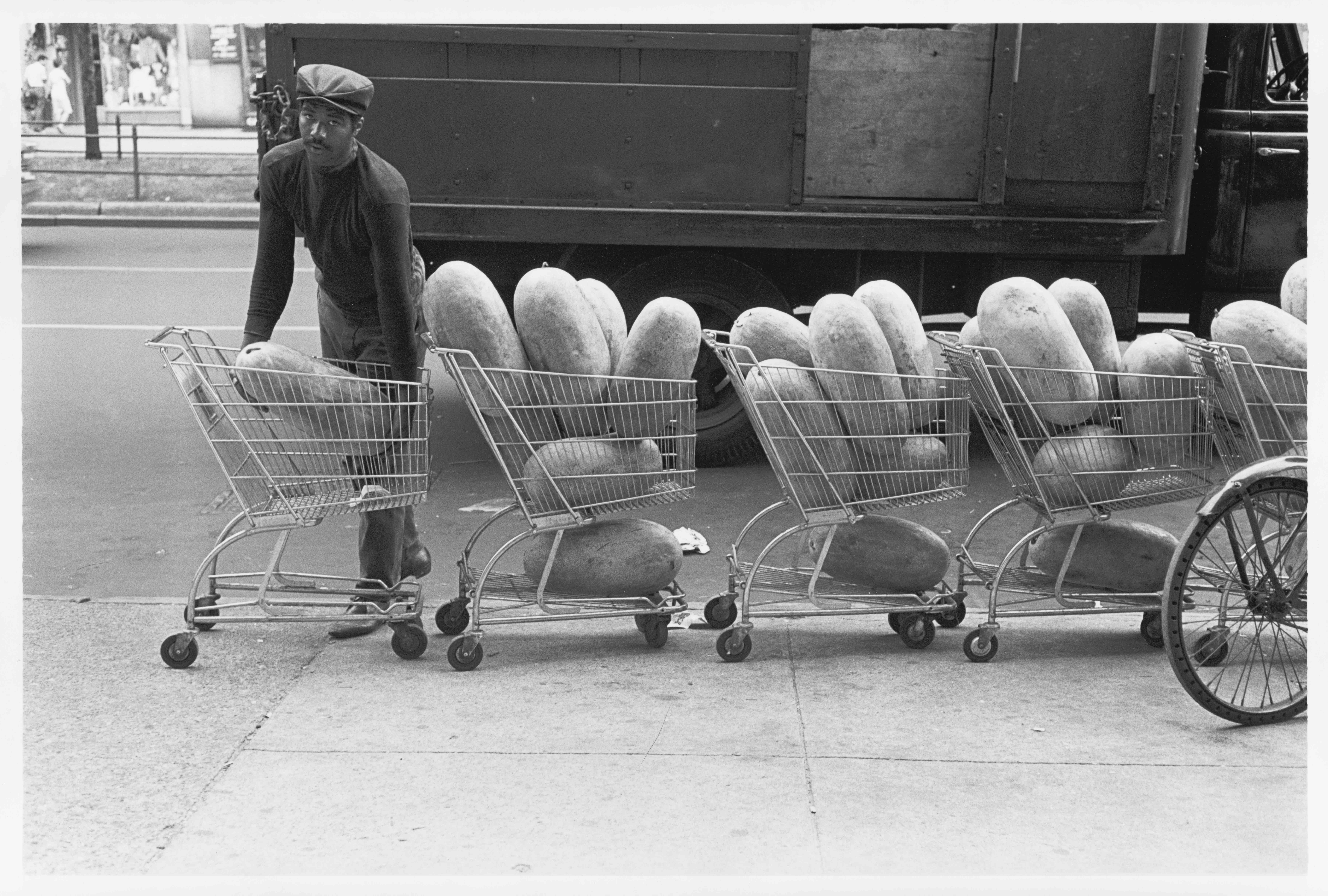 Store vendor with watermelons in shopping carts, 1966