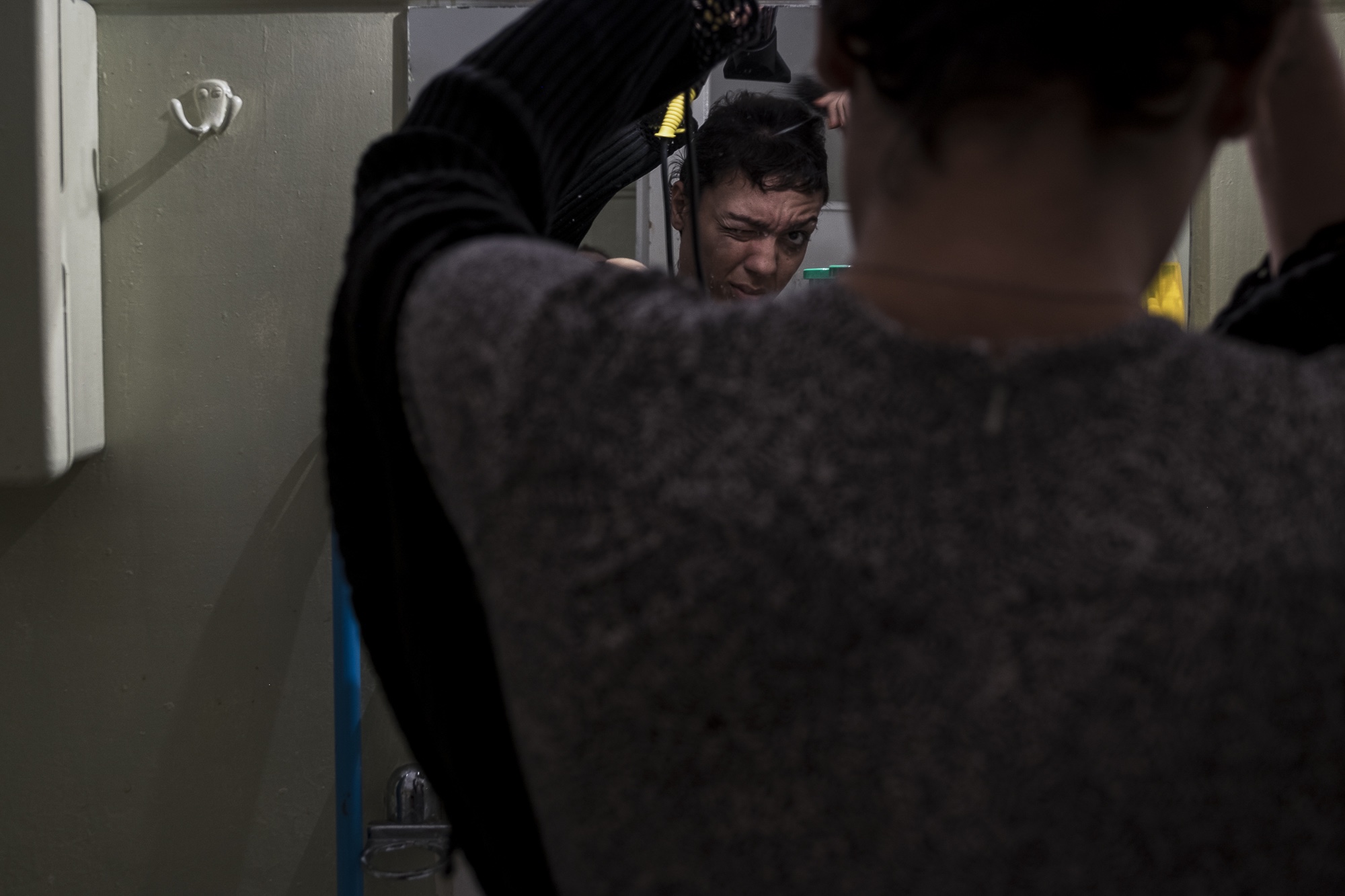Y., 28, a transgender woman from Morocco straightens her hair at a friend's apartment in Athens, Greece. August 6, 2017 